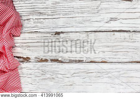 Top View Of An Empty White Wooden Picnic Table And Crumpled Red And White Gingham Tablecloth At The 