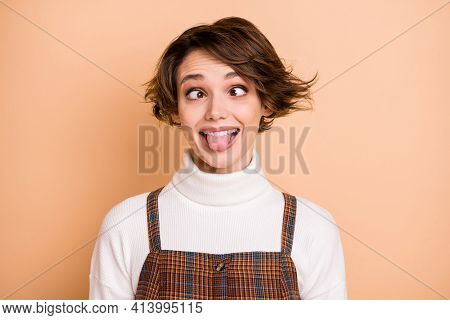 Photo Portrait Of Silly Fooling Grimacing Girl Showing Tongue Isolated On Pastel Beige Color Backgro