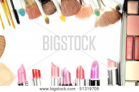 Collection of various lipstick and brushes on a white background
