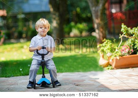 Little Toddler Boy Riding On His Bycicle In Summer