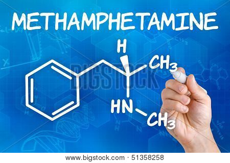 Hand with pen drawing the chemical formula of methamphetamine