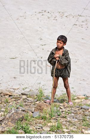 KALANKI, NEPAL - APRIL 2: Portrait of unidentified Nepalese herder boy with a rod on April 2, 2009 in Kalanki Village, Kathmandu, Central Region, Nepal.
