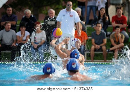 KAPOSVAR, HUNGARY - SEPTEMBER 15: Norbert Juhasz-Szelei (white) in action at a Hungarian championship waterpolo game between Kaposvar (white) vs Honved (blue) on September 15 2013 in Kaposvar, Hungary