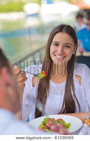 happy young couple having lanch at beautiful restaurant on the beach
