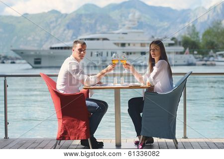 happy young couple having lanch at beautiful restaurant on the beach