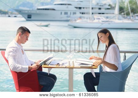 happy young couple having lanch at beautiful restaurant on the beach