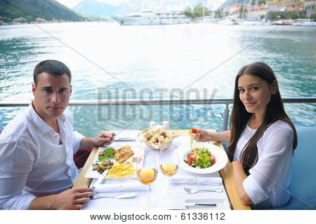 happy young couple having lanch at beautiful restaurant on the beach