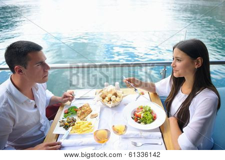 happy young couple having lanch at beautiful restaurant on the beach