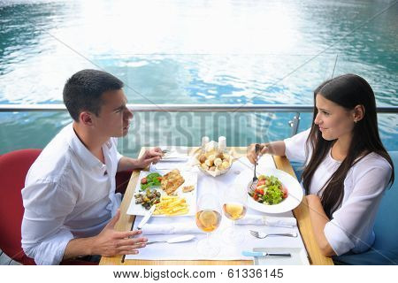 happy young couple having lanch at beautiful restaurant on the beach