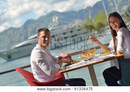 happy young couple having lanch at beautiful restaurant on the beach