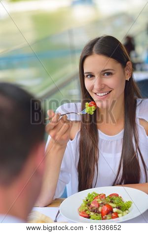 happy young couple having lanch at beautiful restaurant on the beach