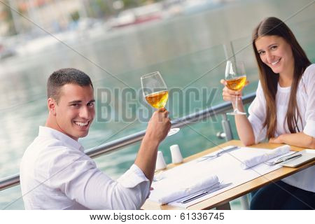 happy young couple having lanch at beautiful restaurant on the beach