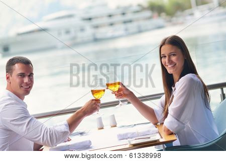 happy young couple having lanch at beautiful restaurant on the beach