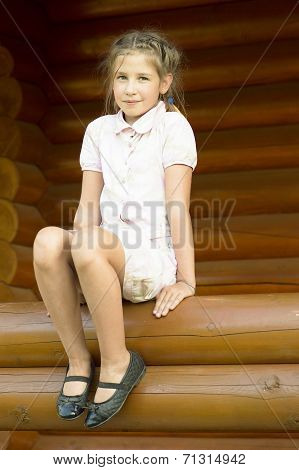 The Girl Is Sittind On A Log.