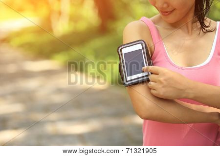 Runner athlete listening to music from smart phone mp3 player smart phone armband.