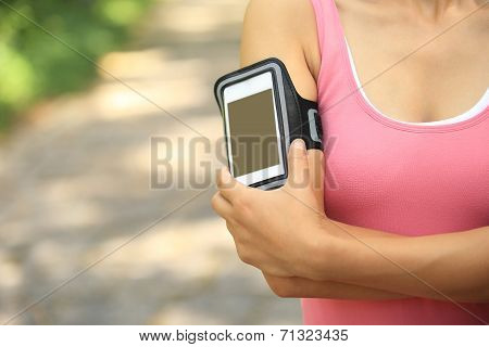 Runner athlete listening to music from smart phone mp3 player smart phone armband.