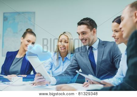 business, technology, cloud computing and people concept - smiling business team with tablet pc computer and virtual cloud projection having discussion in office