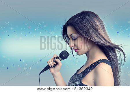 Winter song. Portrait of a beautiful woman with a microphone