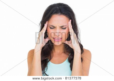 Pretty brunette getting a headache on white background