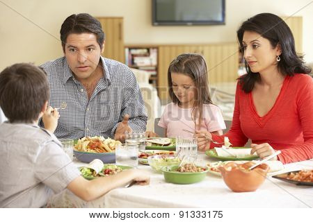 Young Hispanic Family Enjoying Meal At Home