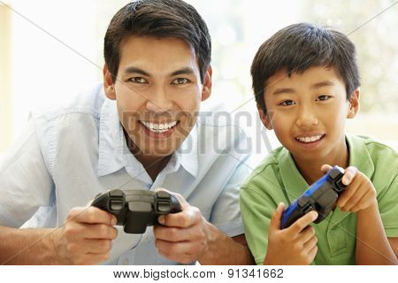 Asian father and son playing videogames