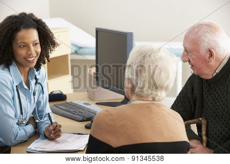 Young female Doctor talking to senior couple