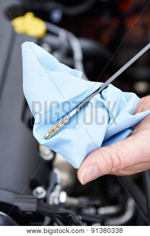 Close-up Of Man Checking Car Engine Oil Level On Dipstick