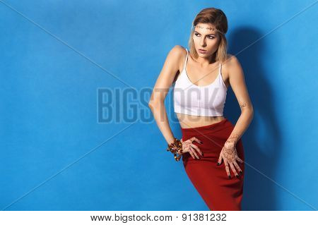 Beautiful Sexy Blonde Woman With Make Up And Mehendi Tattoo In Red Skirt On Blue Background