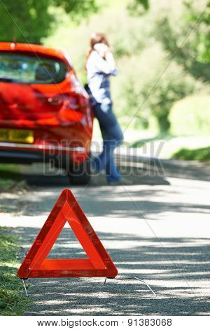 Female Driver Broken Down On Country Road With Warning Sign In F