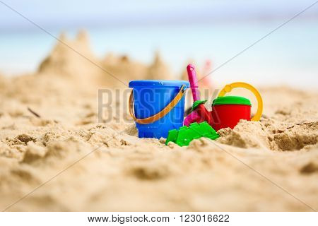Sand castle on tropical beach and kids toys, family vacation