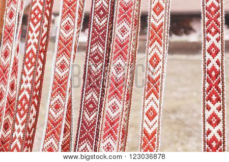 linen belts with ornaments that hang in a row. National belt, handmade. Natural belt sold in the market