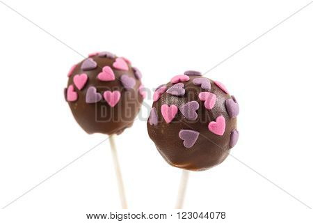 Two chocolate cakepops with hearts decoration on isolated background