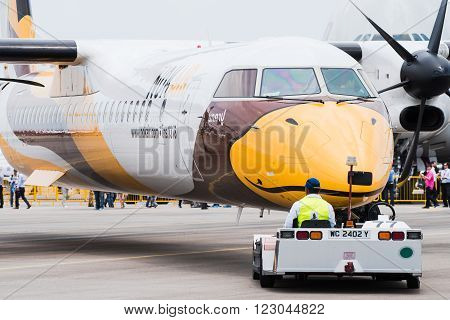 Singapore - February 17 2016: Front of a Bombardier Q400 NextGen in Nok Air livery being pushed into position during Singapore Airshow at Changi Exhibition Centre in Singapore.