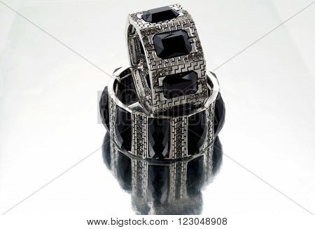 Silver bracelet with black gems on mirrorlike background