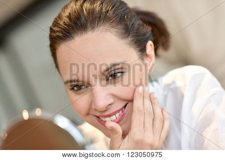 Middle-aged woman looking at mirror