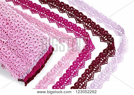 Reddish lace stretched over white background - pink, wine, raspberry-red