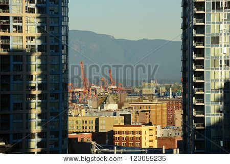 Port of Vancouver and Mount Fromme, viewed across two high rise apartments, Vancouver, British Columbia, Canada.