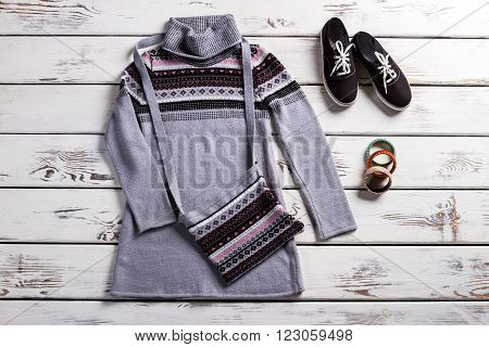 Tunic with keds and purse. Lady's spring outfit on shelf. Simple outfit for cool weather. Clothing and footwear for women.