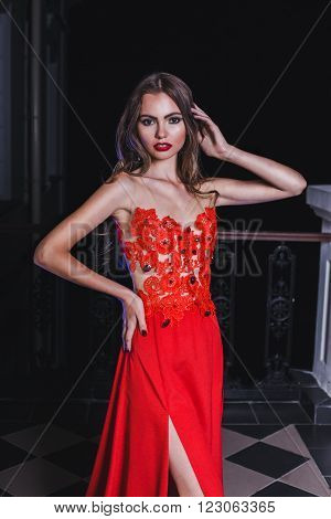 Beautiful Girl In A Red Dress Standing On The Balcony