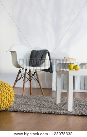 Rest corner in modern lounge with white armchair and coffee table