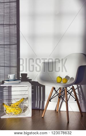 Armchair and coffee table made of box in spacious bright living room with wooden floor