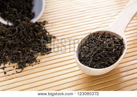 Green tea in a spoon. A scattering of green tea.
