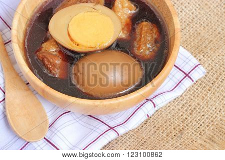 Thai food called "Pa-lo", egg and pork stew with seasonings blend sweet taste and brown sauce in wood bowl