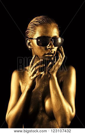 Beautiful young naked woman in gold and sunglasses