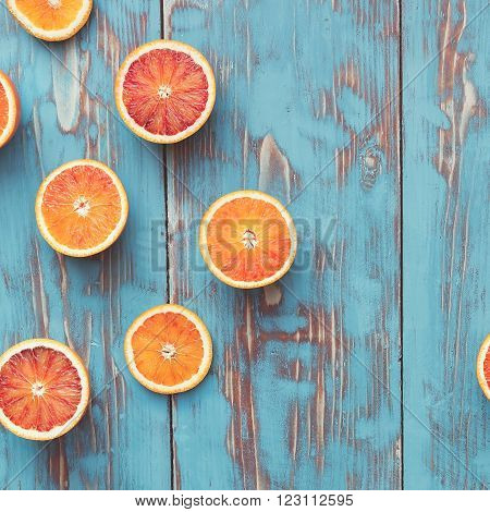 Fresh  blood orange halves on turquoise board. Top view, vintage toned image, blank space