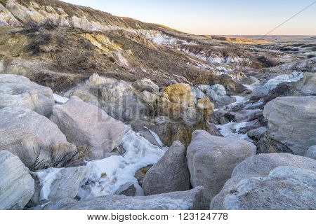 clay and sandstone erosion geological formations in Paint Mine Interpretive Park at Calhan near Colorado Springs, Colorado with a distant view of plains at sunrise