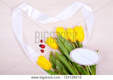 Bouquet of bright yellow tulips on a wooden background