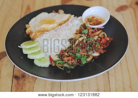 Thai stir-fried pork and basil served with rice and fried egg / Pad kra Prao