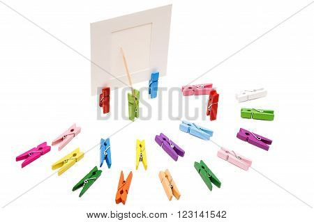 Clothespin is shows a toothpick on a white frame. Other pegs arranged in a semicircle.One is standing