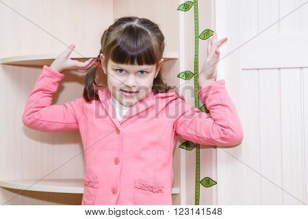 girl standing at the wooden wall near stadiometer
